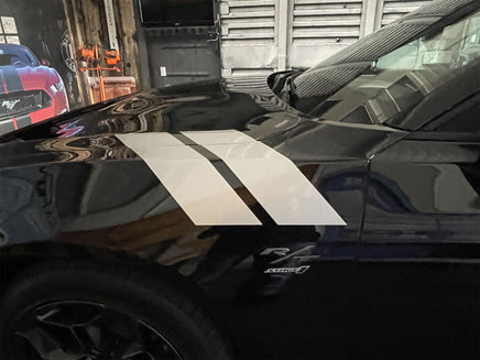 Black Dodge Charger with white racing stripes in a garage setting. 2024-2026 Dodge Charger Double Bar 24 Stripes Hood Hash Marks Mopar Vinyl Graphics 3M Decals
