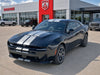 Black 2026 Dodge Charger Sixpack car with white stripes in front of a Dodge dealership