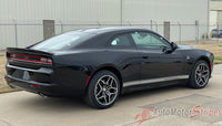Black 2024-2026 Dodge Charger Sixpack  muscle car parked on a concrete surface with a building in the background