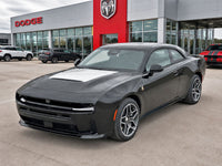 Gray Dodge car parked in front of a Dodge dealership