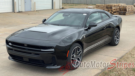 Black 2026 Dodge Charger Sixpack Hood Stripes parked on a concrete surface with a building and pallets in the background.