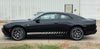Black 2024-2026 Dodge Charger Sixpack muscle car with 'Sixpack' stripe on a white building background