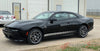 Black 2024-2026 Dodge Charger Sixpack with racing stripes parked in front of a building