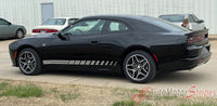 Black 2024-2026 Dodge Charger Sixpack with white racing stripes parked on a concrete surface.