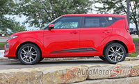 Red Kia Soul with black stripes parked on a stone ledge